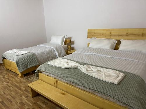 um quarto com duas camas e um banco entre elas em Ardjon House em Berati