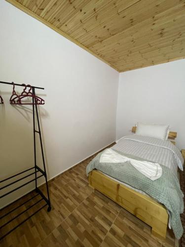 um quarto com uma cama num quarto com tecto em madeira em Ardjon House em Berati