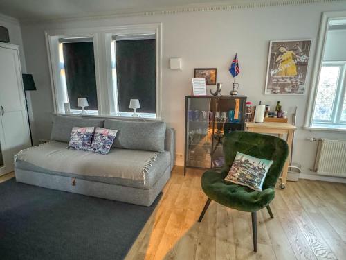 - un salon avec un canapé et une chaise dans l'établissement Enjoy Reykjavík Yellow Door Apartment, à Reykjavik