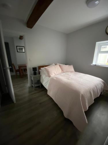 a bedroom with a white bed and a window at The Old Barn one bedroom apartment in Overton in Overton