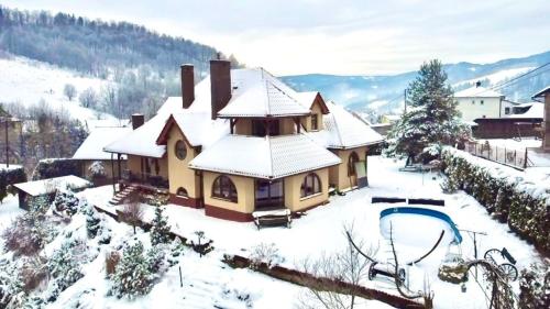 une maison recouverte de neige avec une remontée mécanique dans l'établissement Apartament Zimowa Cisza, à Piwniczna-Zdrój