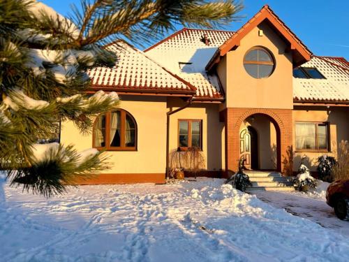 une maison avec de la neige devant elle dans l'établissement Apartament Zimowa Cisza, à Piwniczna-Zdrój