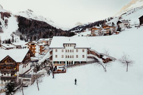 a group of people skiing down a snow covered mountain at Hotel Alpenrose in Arabba