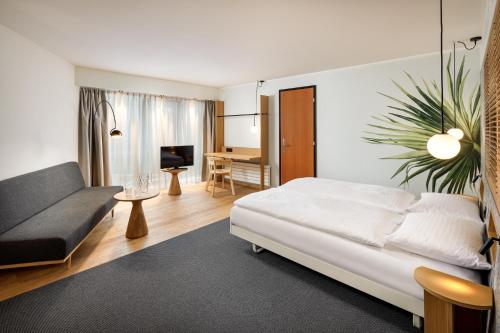 ein Wohnzimmer mit einem Bett und einem Sofa in der Unterkunft Palmiers by Fassbind in Lausanne