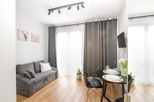 een woonkamer met een bank en een tafel bij Apartamenty Piastowska in Nysa