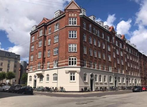 un grand bâtiment en briques avec des vélos garés devant lui dans l'établissement Penthouse: Copenhagen delight, à Copenhague