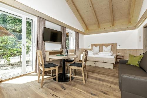 a living room with a desk and a bed at Wellness-Appartements Berchtesgadener Land in Ainring