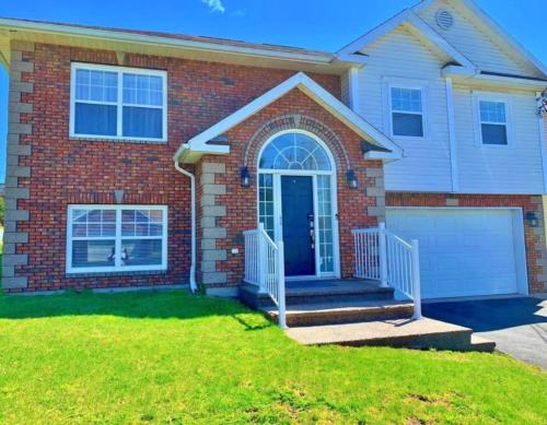 una casa in mattoni con una porta blu e un prato di Vito Place a Halifax