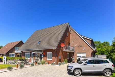 una casa con un coche aparcado delante de ella en Ferienwohnungen Haus Boje, en Neuharlingersiel