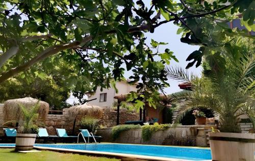 een zwembad met stoelen en een huis op de achtergrond bij Villa Komitata-Pool and Jacuzzi in Balchik