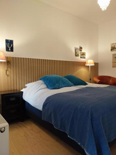 una camera da letto con un grande letto con cuscini blu di B&B Noordwijk Binnen a Noordwijk