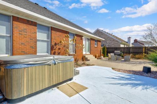 ルイスビルにあるSpacious Derby Home with Hot Tubの塀と玄関のあるレンガ造りの家