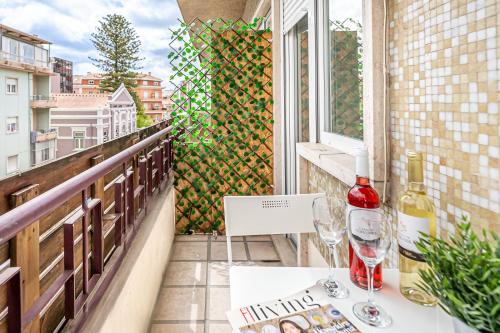 a balcony with a table and two glasses of wine at Santos Mattos Guesthouse & Apartments by Lisbon with Sintra in Amadora