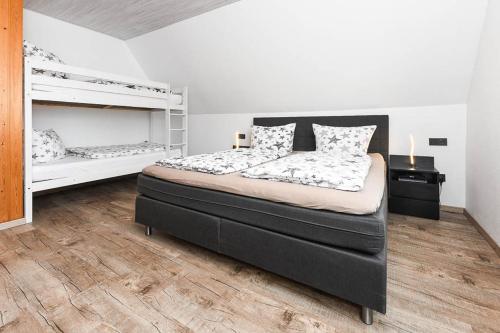 1 dormitorio con 1 cama grande y 2 literas en Ferienwohnungen Haus Boje, en Neuharlingersiel