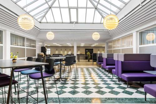 une salle de conférence avec des chaises et des tables violettes dans l'établissement Best Western Plus Park Globetrotter Copenhagen Airport, à Copenhague