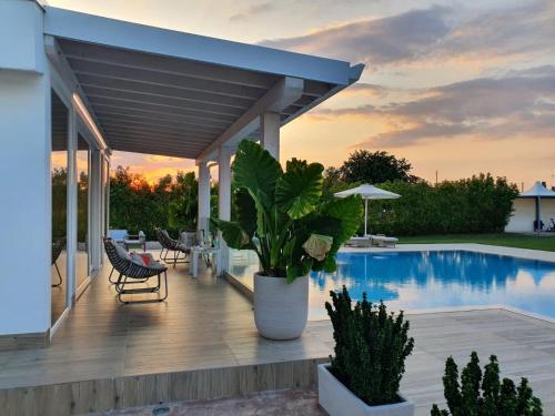 a patio with a table and chairs next to a pool at Female Resort in San Felice Circeo