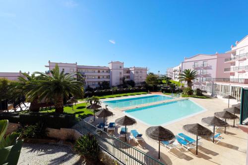 uitzicht op een zwembad met parasols en stoelen bij B95 - Casa Melo Apartment in Praia da Luz in Luz