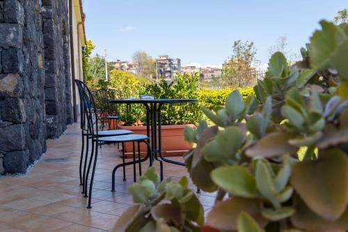 un patio avec des chaises, une table et des plantes dans l'établissement Best Western Hotel Santa Caterina, à Acireale