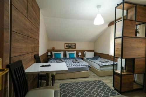 um quarto com 2 camas, uma mesa e uma sala de jantar em Studio Apartments Maksimović em Niš