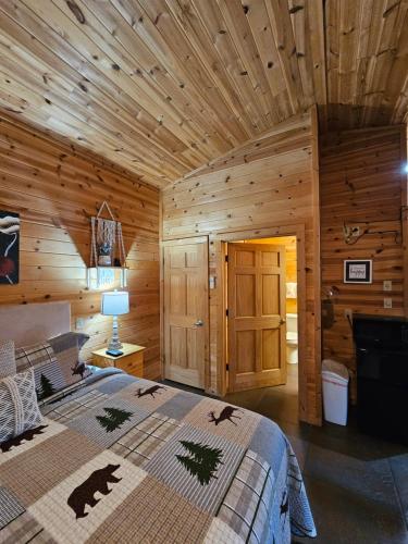 a bedroom with a bed in a wooden cabin at Honey Bear Haven Suite 5 in Eureka Springs