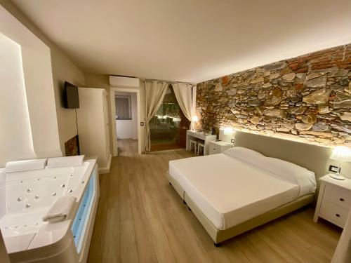 een slaapkamer met een bed en een stenen muur bij Il Tiglio Jacuzzi&Sauna in Lucca