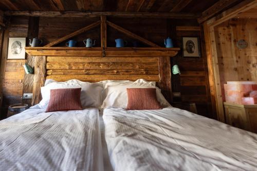 a bedroom with a bed with two red pillows at Café Quinson Relais de Charme in Morgex