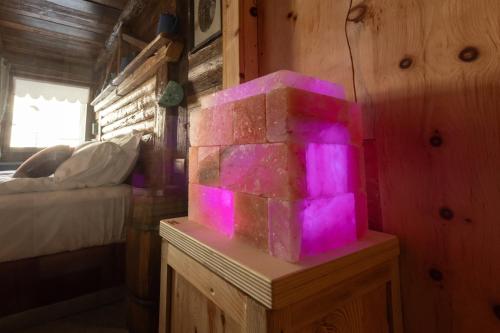 a room with a brick fireplace with purple lights at Café Quinson Relais de Charme in Morgex