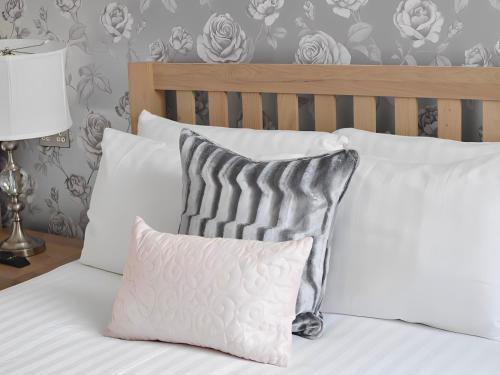 a bed with white pillows and a gray and white pillow at The Star Hotel in Southampton