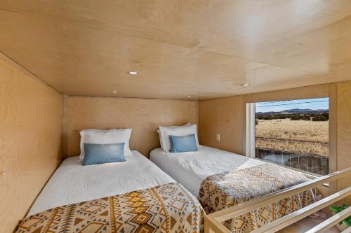 2 camas en una habitación pequeña con ventana en Tiny home near Grand Canyon sleeps 5, epic views!, en Flagstaff