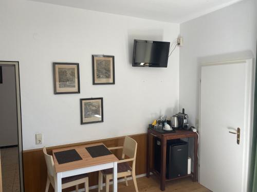 a room with a table and a television on a wall at Zum Rayers Café-Restaurant & Boutique-Hotel 