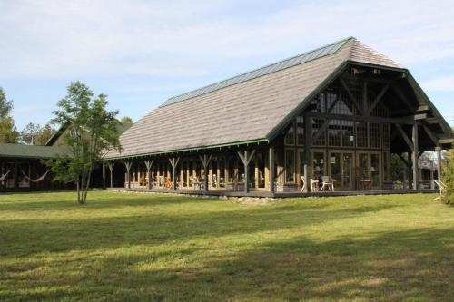 a large wooden building with a grass field at Chill Inn in Bernāti