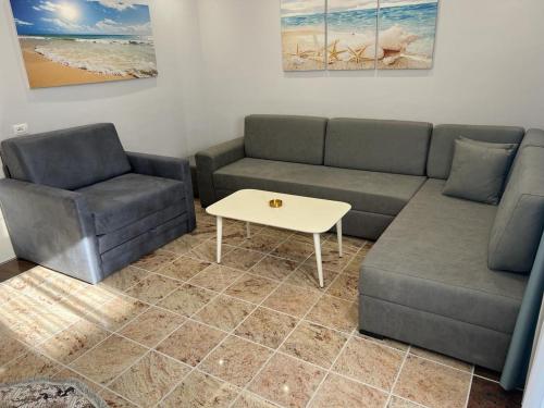 - un salon avec un canapé et une table basse dans l'établissement Fishta apartments Q5 35, à Velipojë