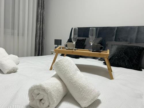 uma mesa com dois copos de vinho em cima de uma cama em Nastasija apartment em Osijek