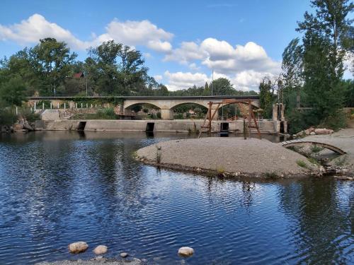 a bridge over a river with rocks in the water at Casa de Alagoa in Arganil