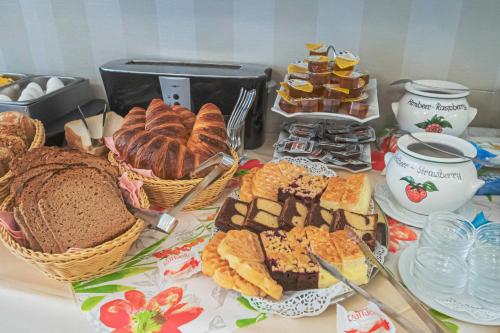 una mesa cubierta con diferentes tipos de pan y repostería en Hotel Villa am Kurpark, en Bad Homburg vor der Höhe