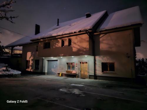 una casa con nieve en el techo por la noche en Tourist farm Megušar, en Škofja Loka