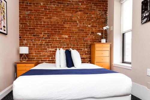 Posto letto in camera con muro di mattoni di Stylish Studio in Boston Brownstone, C.Ave #21 a Boston