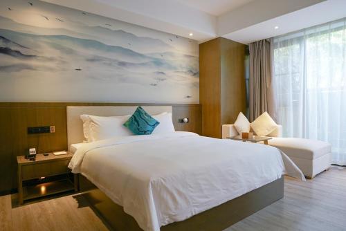 a bedroom with a large white bed and a window at Paco Hotel Tiyuxilu Metro Guangzhou-Free Shuttle Bus for Canton Fair in Guangzhou