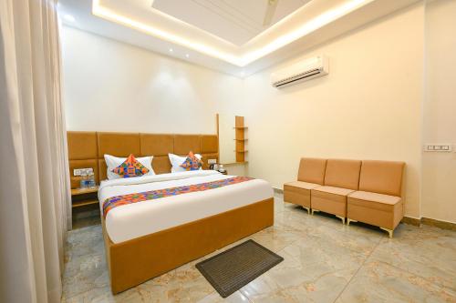 a bedroom with a large bed and two chairs at FabHotel Flying Kiwi in Mohali