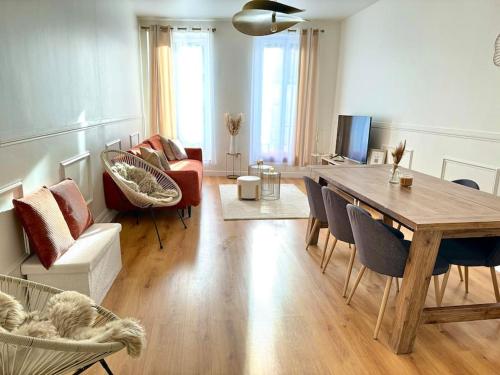 a living room with a wooden table and chairs at Appartement avec magnifique vue sur la Saône et son balcon in Chalon-sur-Saône