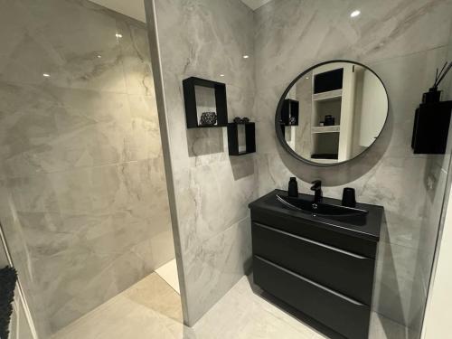 a bathroom with a black sink and a mirror at Appartement avec magnifique vue sur la Saône et son balcon in Chalon-sur-Saône