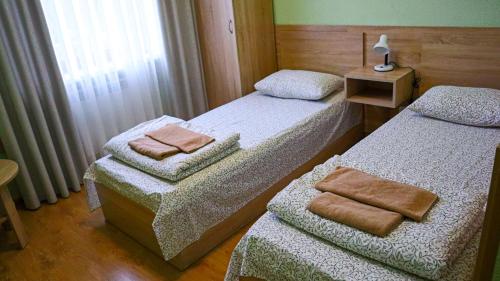 a room with two beds with towels on them at Каприз in Kamianets-Podilskyi