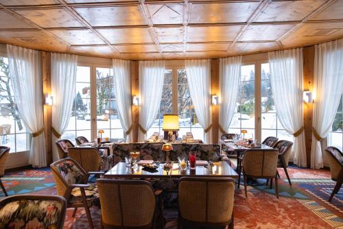 un comedor con mesas y sillas y la torre eiffel en Hotel Adula, en Flims