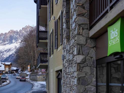 een bord aan de zijkant van een gebouw naast een straat bij ibis Styles Les Houches Chamonix in Les Houches