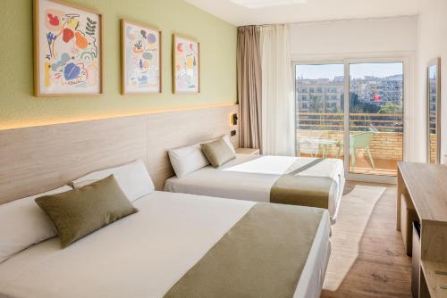 a hotel room with two beds and a window at Hotel Jaime I in Salou