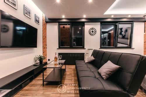 a living room with a couch and a table at Happy Night - ApartamentyHappy pl in Mielec