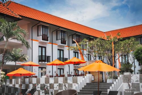 widok na hotel z pomarańczowymi parasolami w obiekcie HARRIS Hotel Kuta Tuban Bali w mieście Kuta