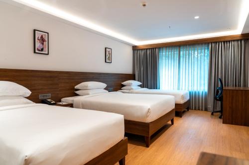 เตียงในห้องที่ Lilac Hotel Guruvayur