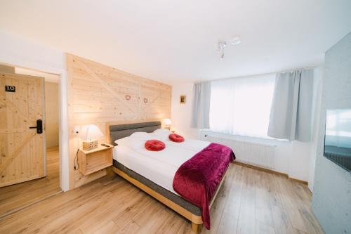 a bedroom with a bed with two red pillows on it at Black Forest Dream Apartments in Feldberg