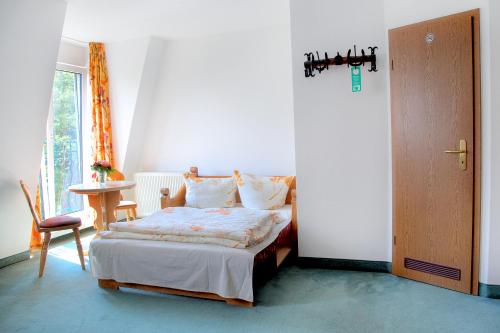 een slaapkamer met een bed, een tafel en een raam bij Hotel am Liepnitzsee in Wandlitz